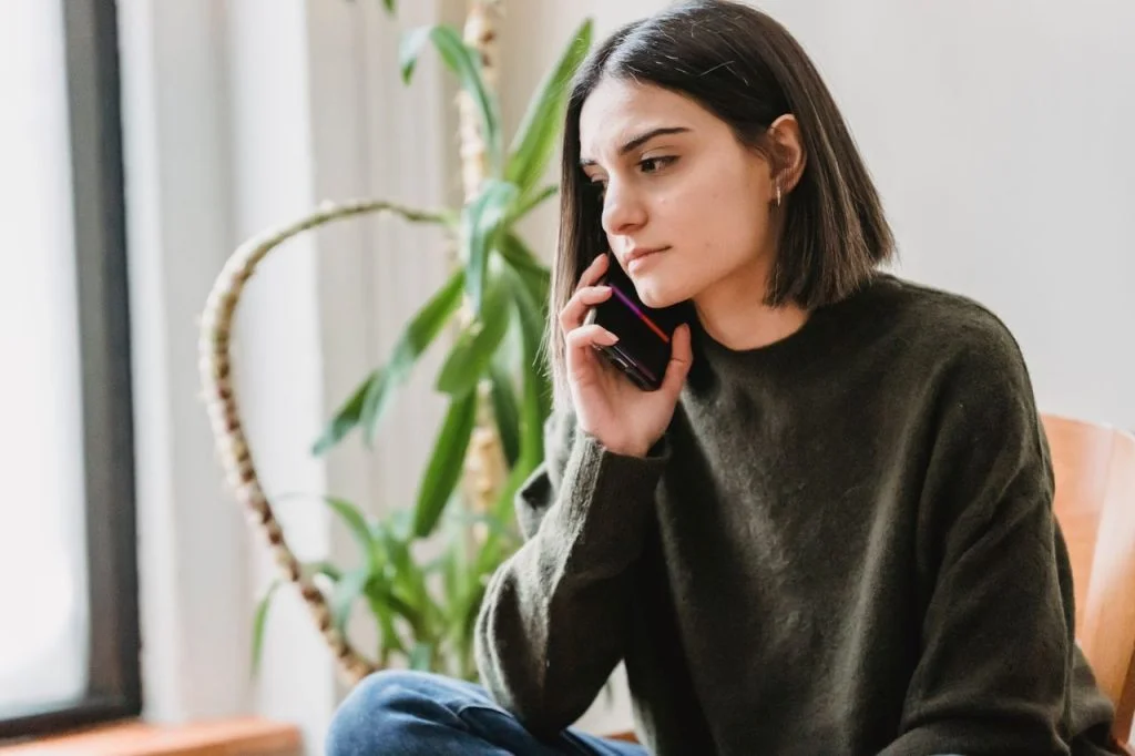 femme pensive au téléphone appelant un homme